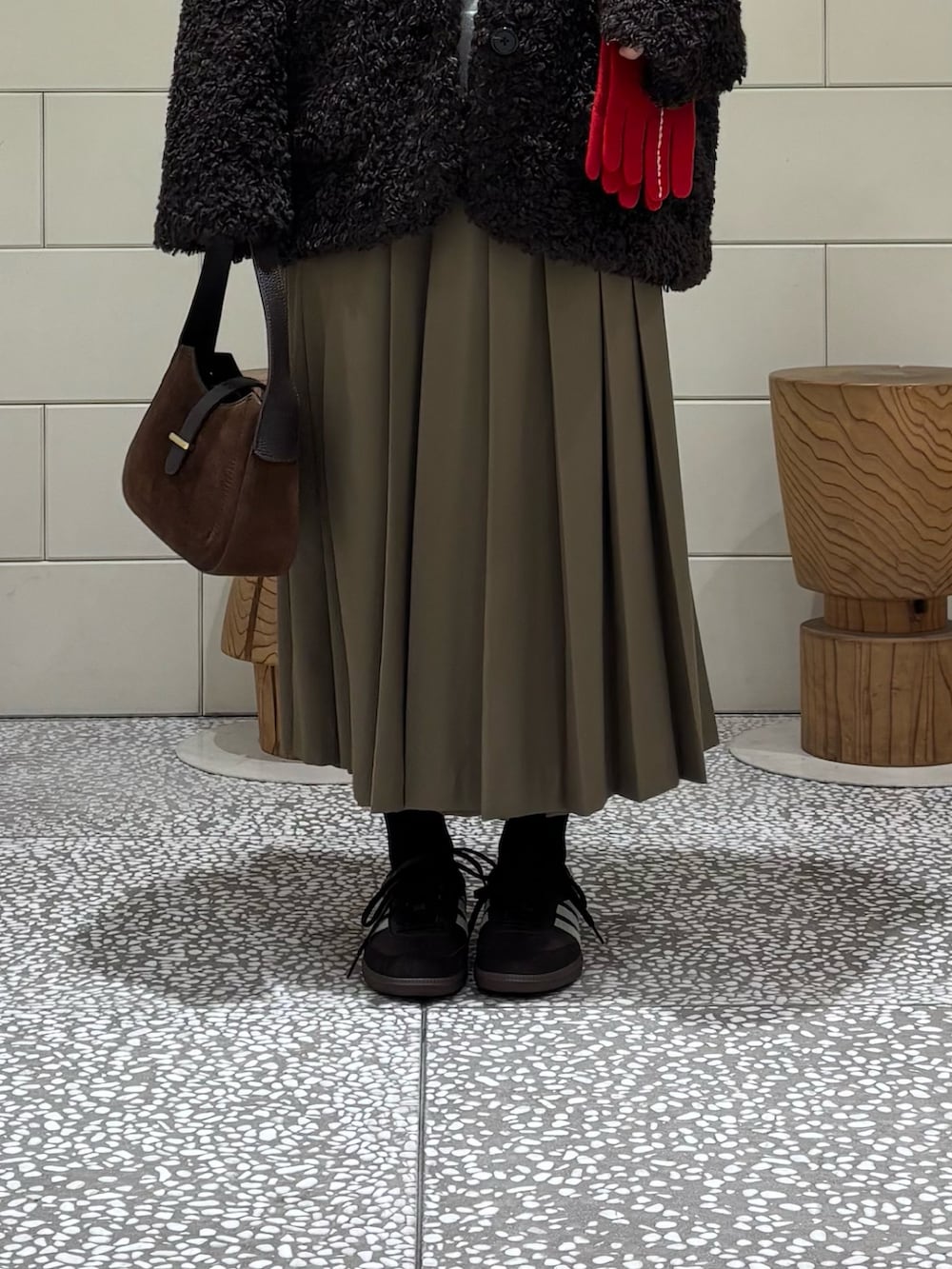 ブラウン系のスニーカー、グリーン系のスカート、ブラウン系のその他アウターを着用したレディースの秋コーディネートの6枚目の写真