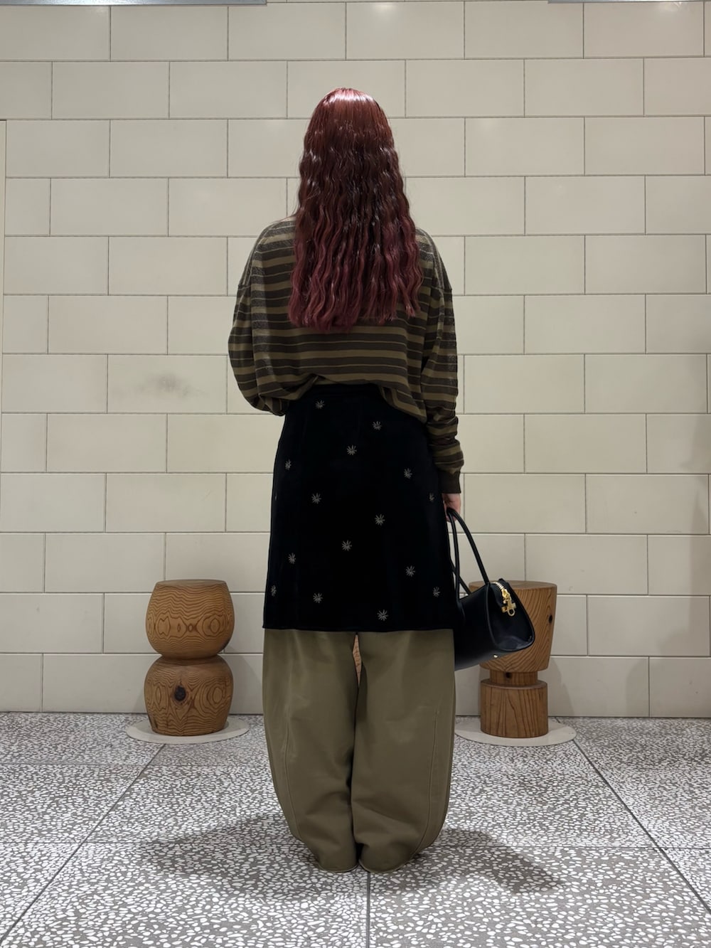 グリーン系のニット/セーター、ブラック系のスカート、ベージュ系のその他パンツを着用したレディースの秋コーディネートの2枚目の写真