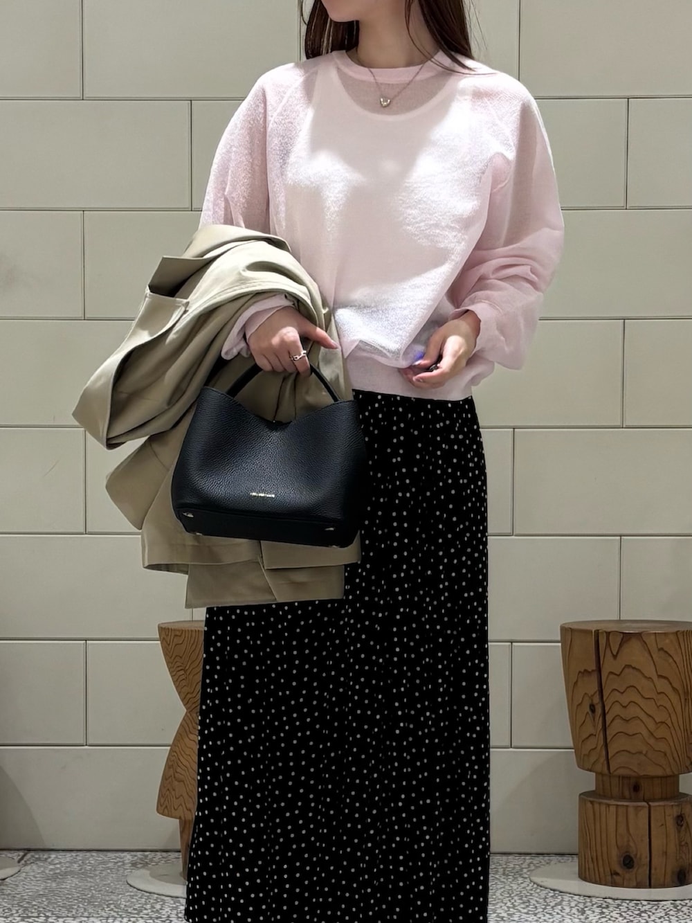 ホワイト系のタンクトップ、ピンク系のニット/セーター、ブラック系のスカートを着用したレディースの冬コーディネートの4枚目の写真