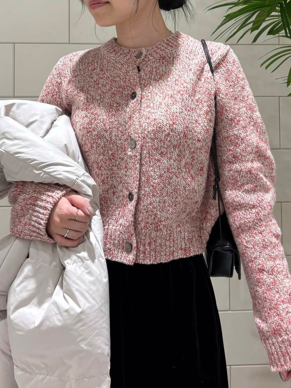 ブラック系のスカート、ベージュ系のカーディガン/ボレロ、ホワイト系のダウンジャケット/コートを着用したレディースの冬コーディネートの5枚目の写真