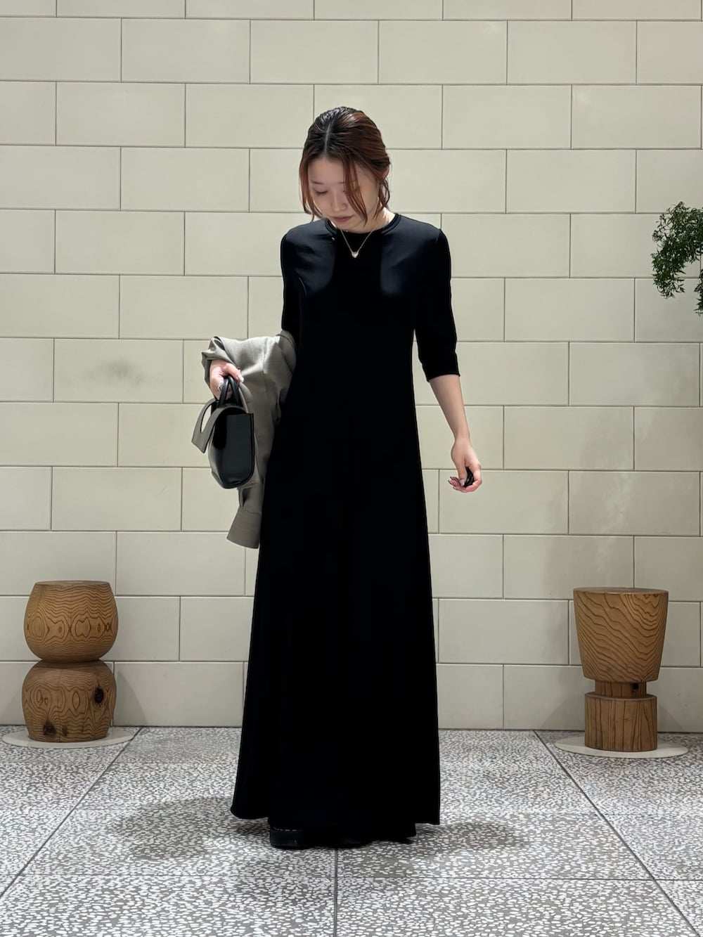 ブラック系のワンピース、ベージュ系のシャツ/ブラウス、ブラック系のハンドバッグを着用したレディースの冬コーディネートの4枚目の写真