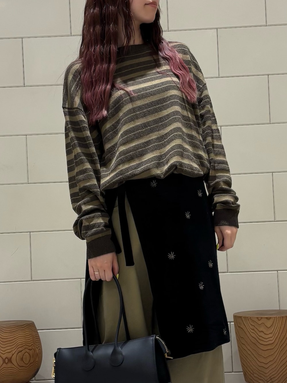 グリーン系のニット/セーター、ブラック系のスカート、ベージュ系のその他パンツを着用したレディースの秋コーディネートの4枚目の写真