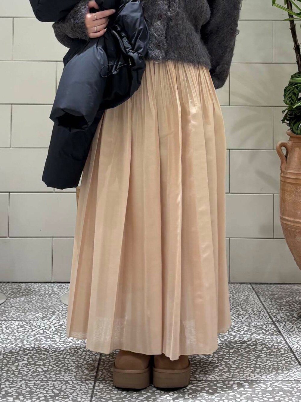 イエロー系のスカート、ブラウン系のカーディガン/ボレロ、ブラウン系のブーツを着用したレディースの冬コーディネートの6枚目の写真