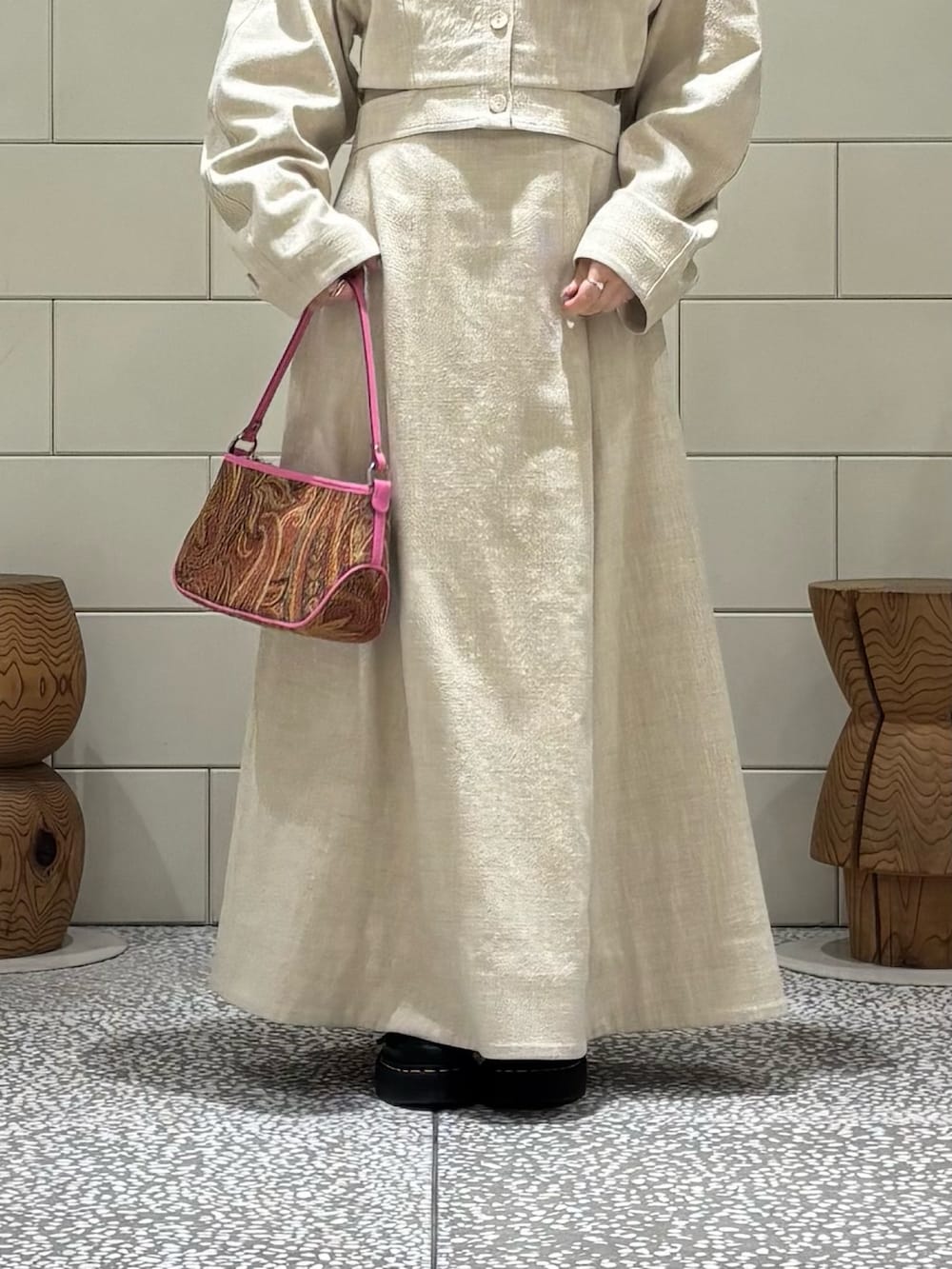 ベージュ系のその他アウター、ベージュ系のスカート、オレンジ系のハンドバッグを着用したレディースの春コーディネートの4枚目の写真