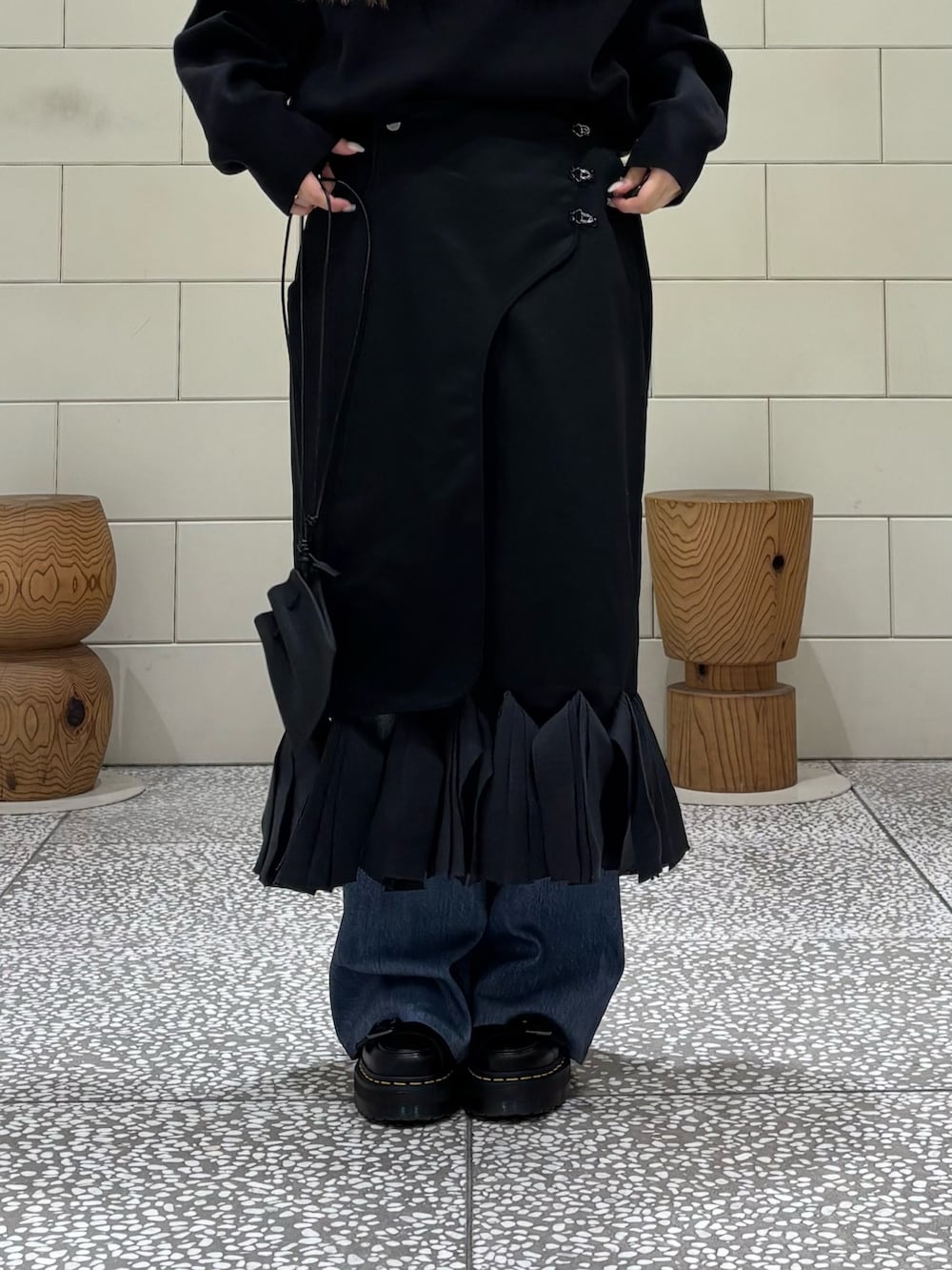 ブラック系のニット/セーター、ブルー系のその他パンツ、ブラック系のスカートを着用したレディースの秋コーディネートの4枚目の写真