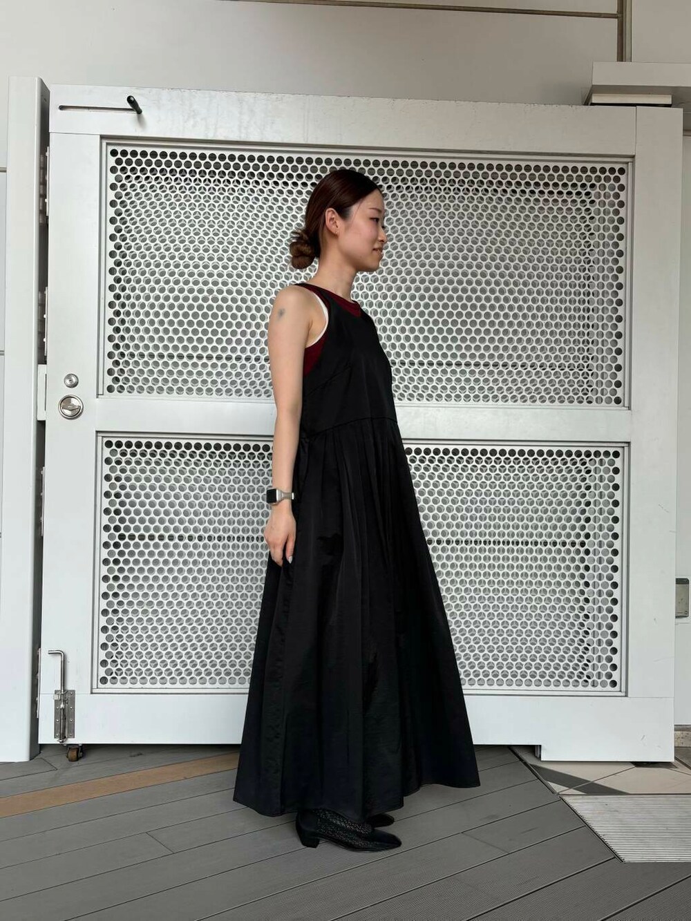 ブラック系のパンプス、レッド系のタンクトップ、ブラック系のワンピースを着用したレディースの夏コーディネートの2枚目の写真