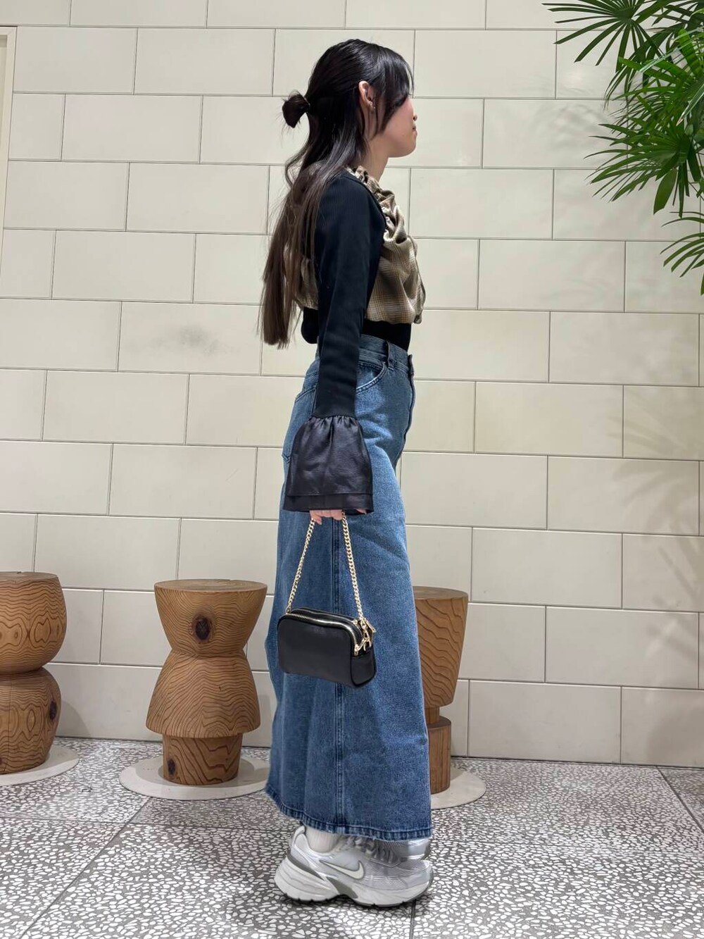 ブラック系のショルダーバッグ、その他のその他トップス、ブラック系のTシャツ/カットソーを着用したレディースの冬コーディネートの3枚目の写真