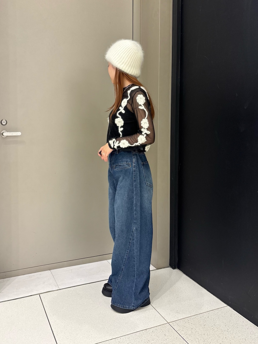ブラック系のその他トップス、ブルー系のデニムパンツ、ブラック系のサンダルを着用したレディースの秋コーディネートの2枚目の写真