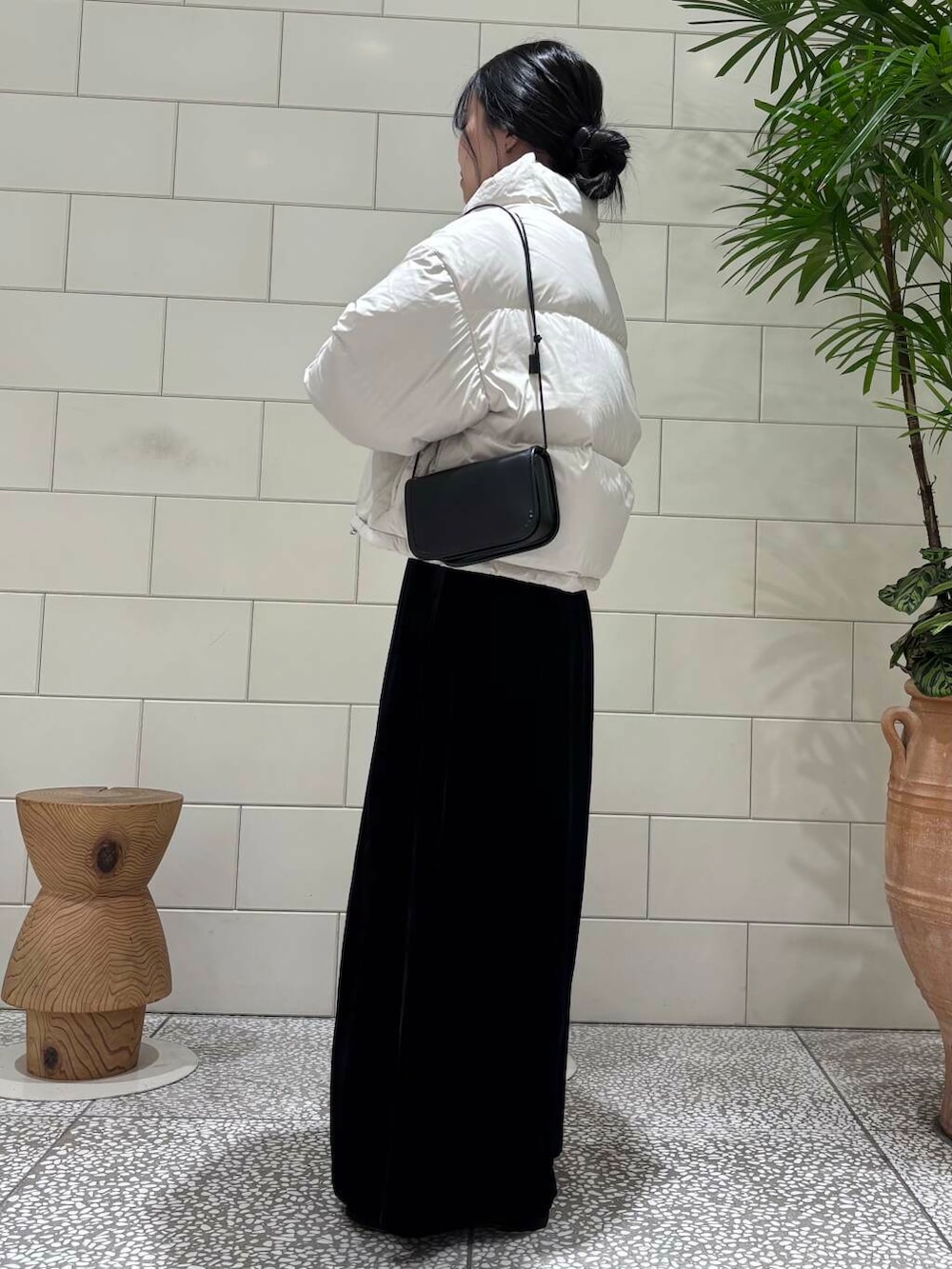 ブラック系のスカート、ベージュ系のカーディガン/ボレロ、ホワイト系のダウンジャケット/コートを着用したレディースの冬コーディネートの3枚目の写真