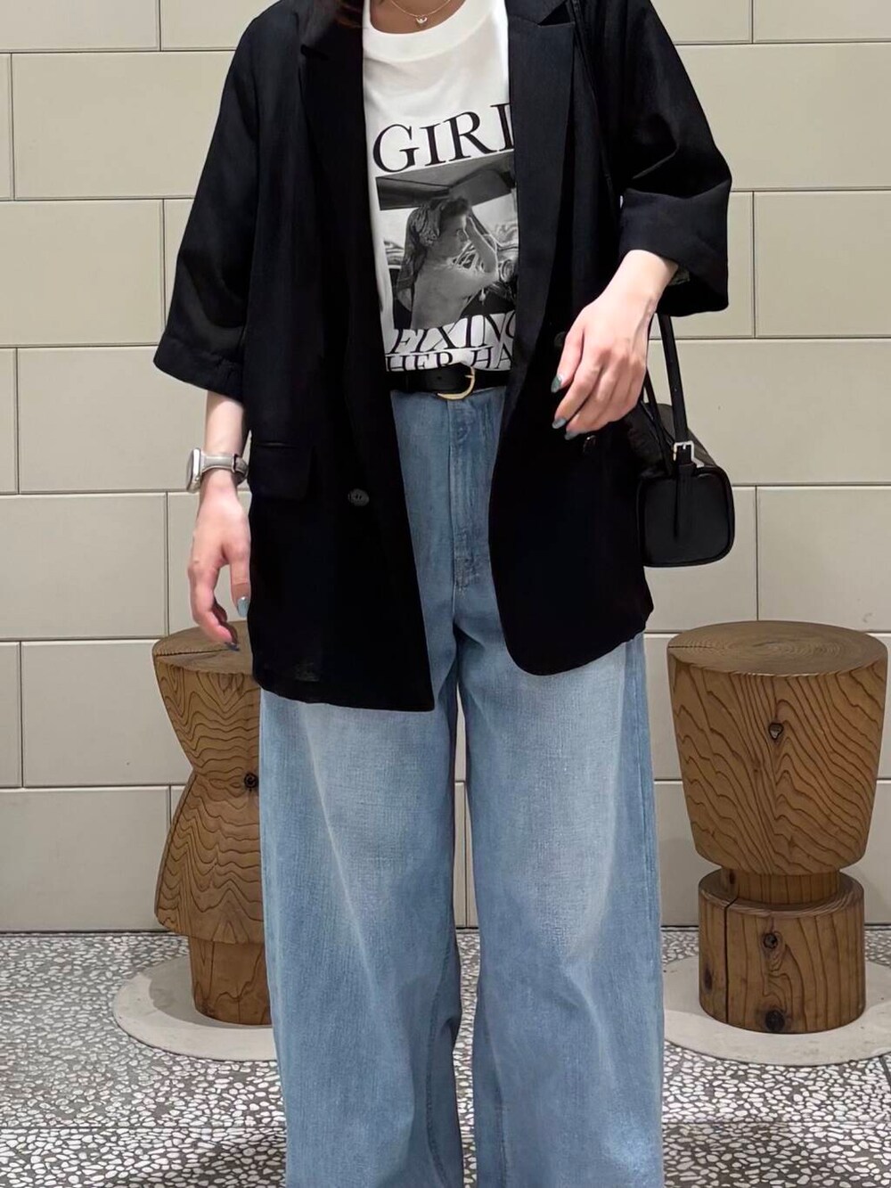 ブルー系のデニムパンツ、ブラック系のその他アウター、ブラック系のショルダーバッグを着用したレディースの夏コーディネートの3枚目の写真