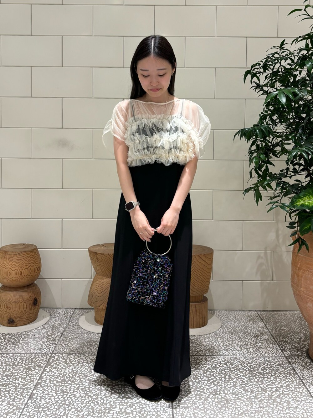 ブラック系のワンピース、パープル系のハンドバッグ、シルバー系のネックレスを着用したレディースの秋コーディネートの2枚目の写真