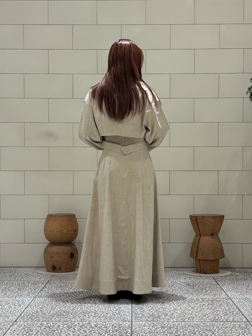 ベージュ系のその他アウター、ベージュ系のスカート、オレンジ系のハンドバッグを着用したレディースの春コーディネートの2枚目の写真