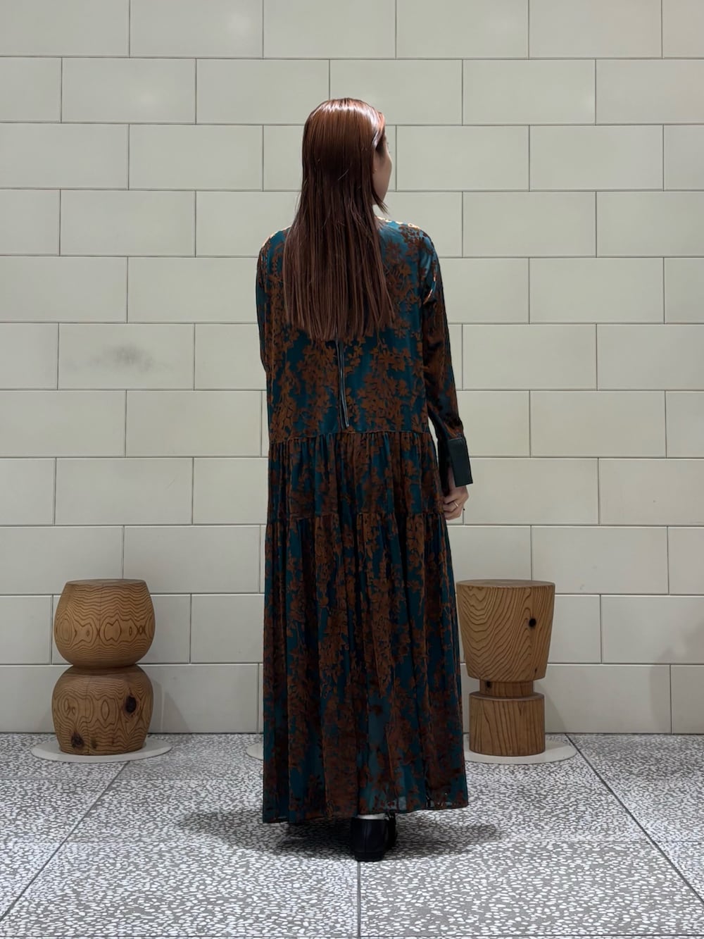 グリーン系のワンピース、ブラック系のハンドバッグ、ブラック系のバレエシューズを着用したレディースの秋コーディネートの2枚目の写真