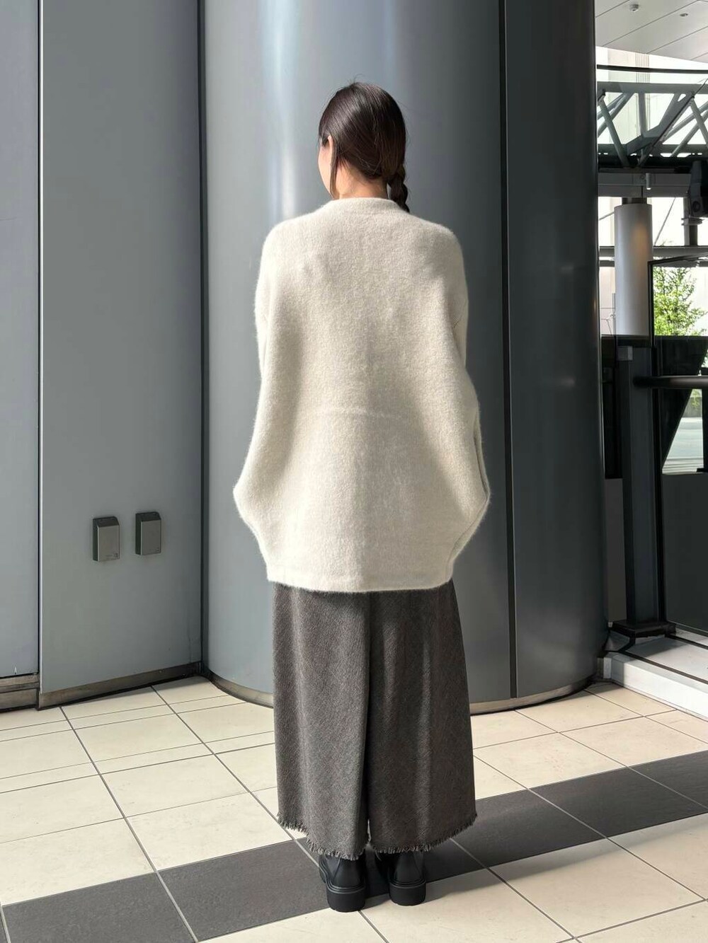 ホワイト系のTシャツ/カットソー、ブラック系のブーツ、グレー系のカーディガン/ボレロを着用したレディースの秋コーディネートの3枚目の写真