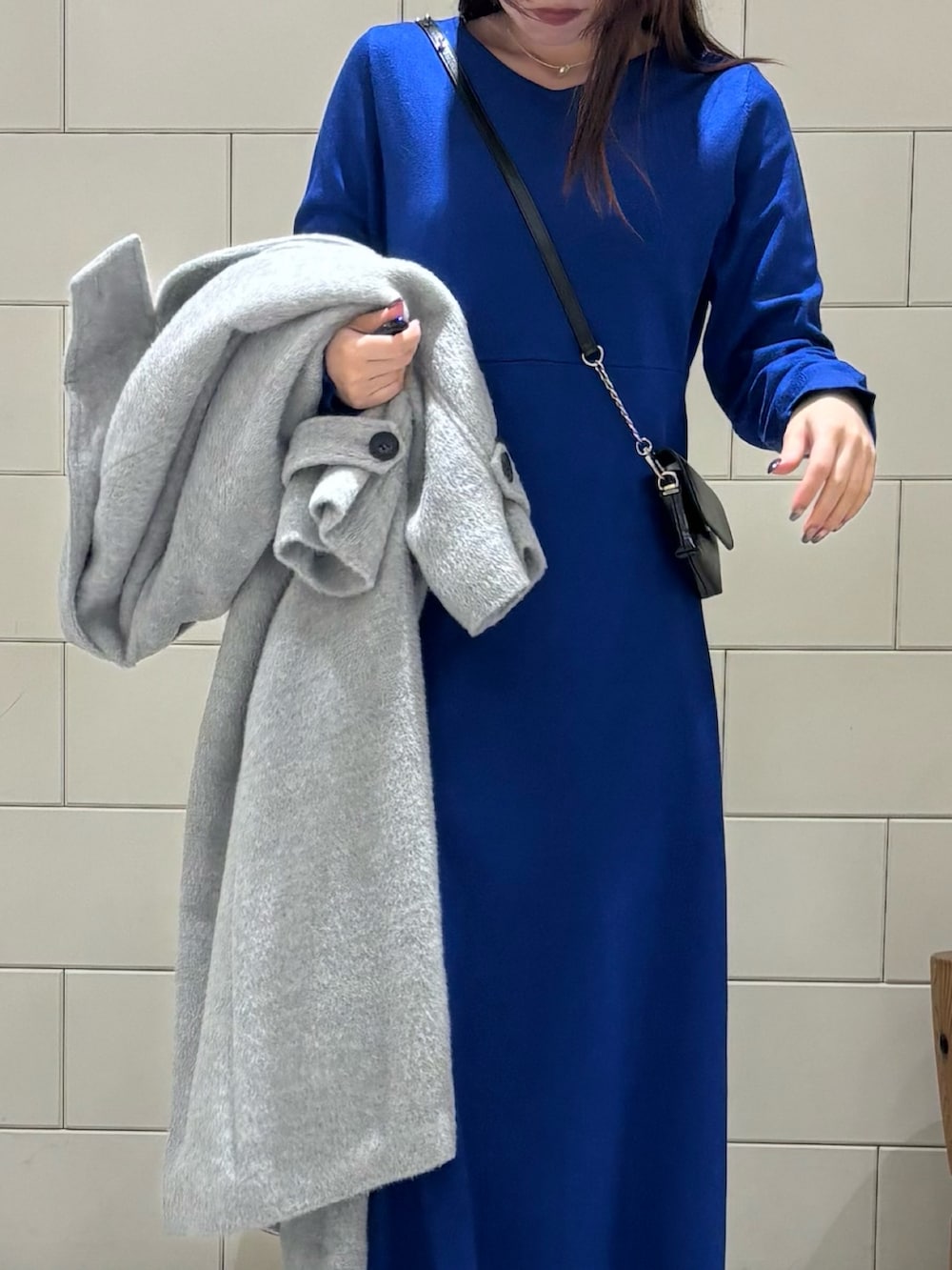 ブラック系のショルダーバッグ、ブラック系のブーツ、グレー系のその他アウターを着用したレディースの冬コーディネートの6枚目の写真