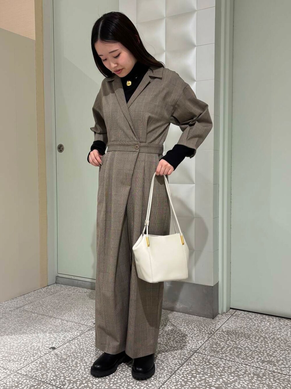 ブラック系のTシャツ/カットソー、ブラック系のブーツ、ホワイト系のトートバッグを着用したレディースの秋コーディネートの2枚目の写真