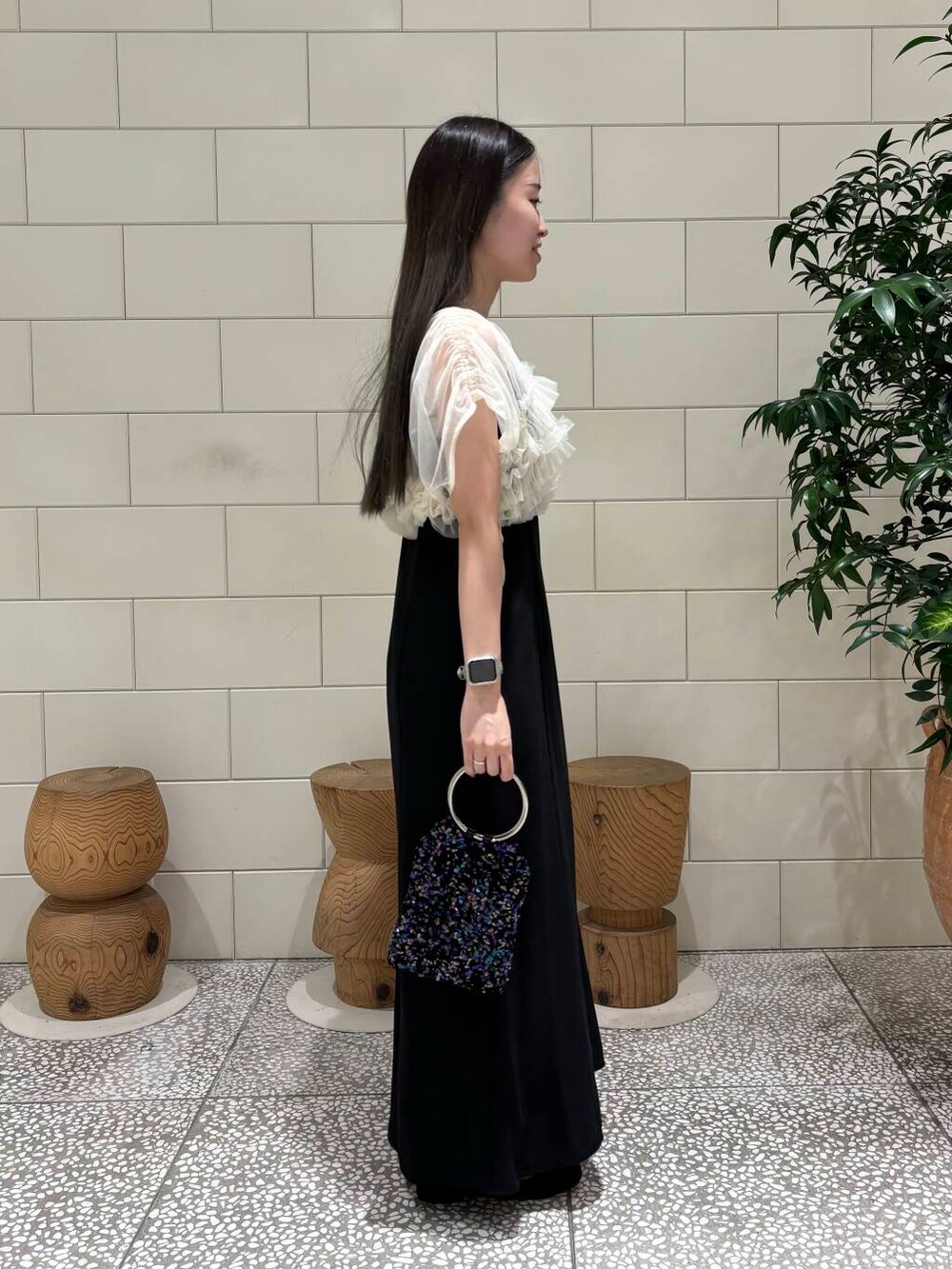 ブラック系のワンピース、パープル系のハンドバッグ、ブラック系のパンプスを着用したレディースの秋コーディネートの3枚目の写真