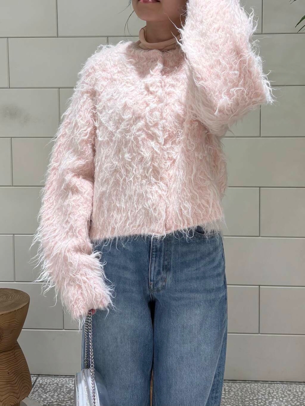 ピンク系のTシャツ/カットソー、ブルー系のデニムパンツ、シルバー系のショルダーバッグを着用したレディースの冬コーディネートの4枚目の写真