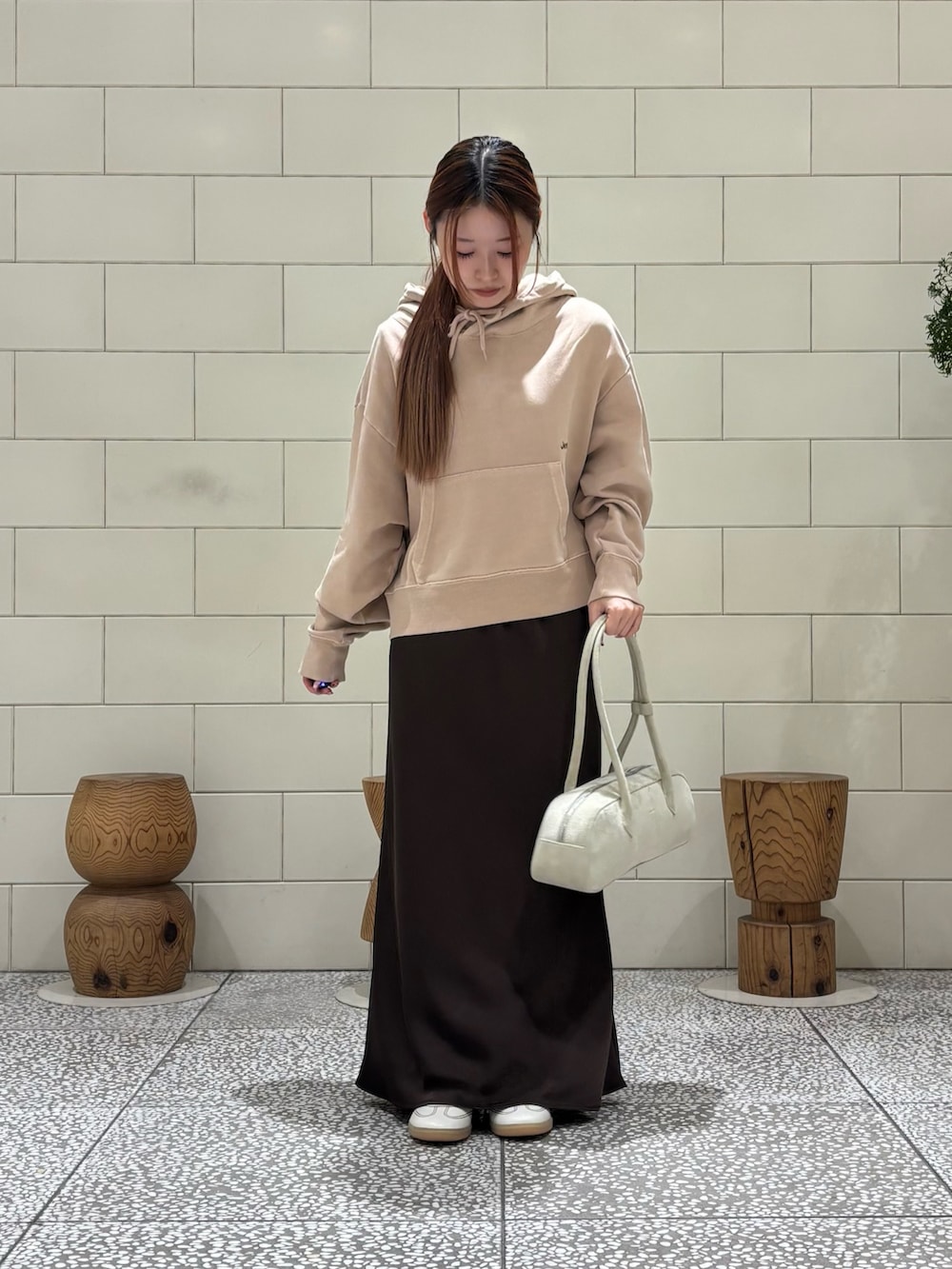 ホワイト系のスニーカー、ブラウン系のスカートを着用したレディースの冬コーディネートの2枚目の写真