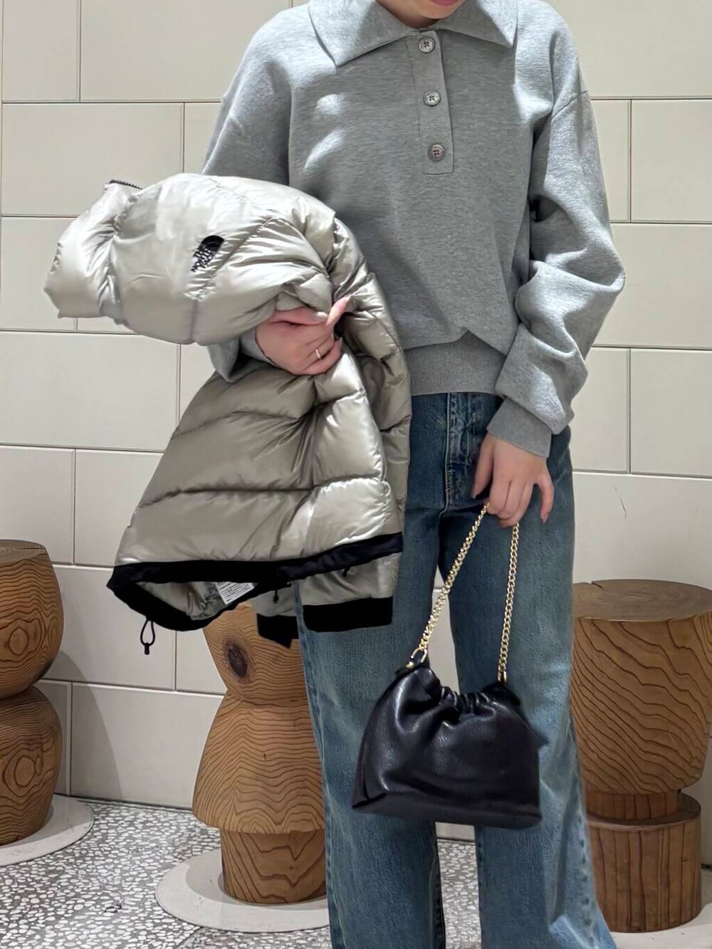 ホワイト系のスニーカー、グレー系のダウンジャケット/コート、ブルー系のデニムパンツを着用したレディースの冬コーディネートの6枚目の写真