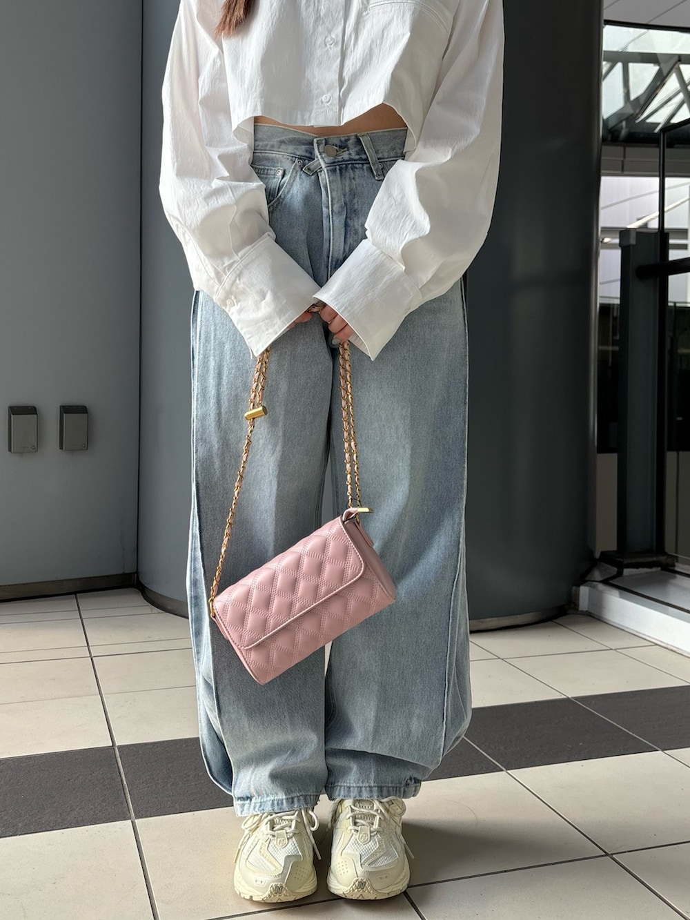 ブルー系のデニムパンツ、ホワイト系のシャツ/ブラウス、ピンク系のショルダーバッグを着用したレディースの夏コーディネートの4枚目の写真