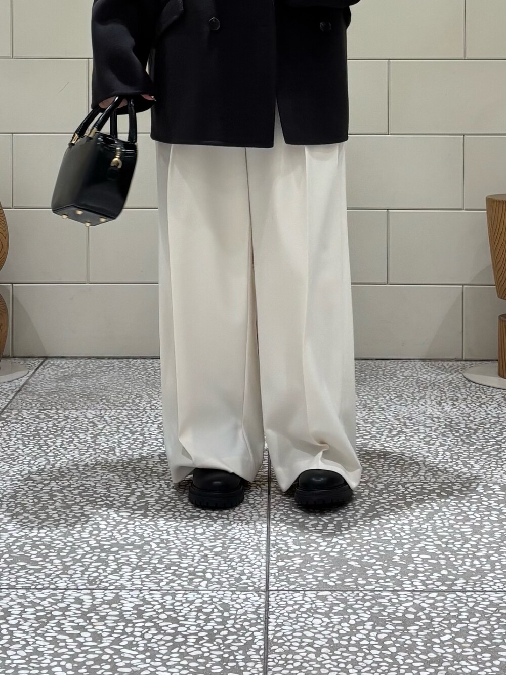 グレー系のニット/セーター、グレー系のその他アウター、ホワイト系のその他パンツを着用したレディースの秋コーディネートの4枚目の写真