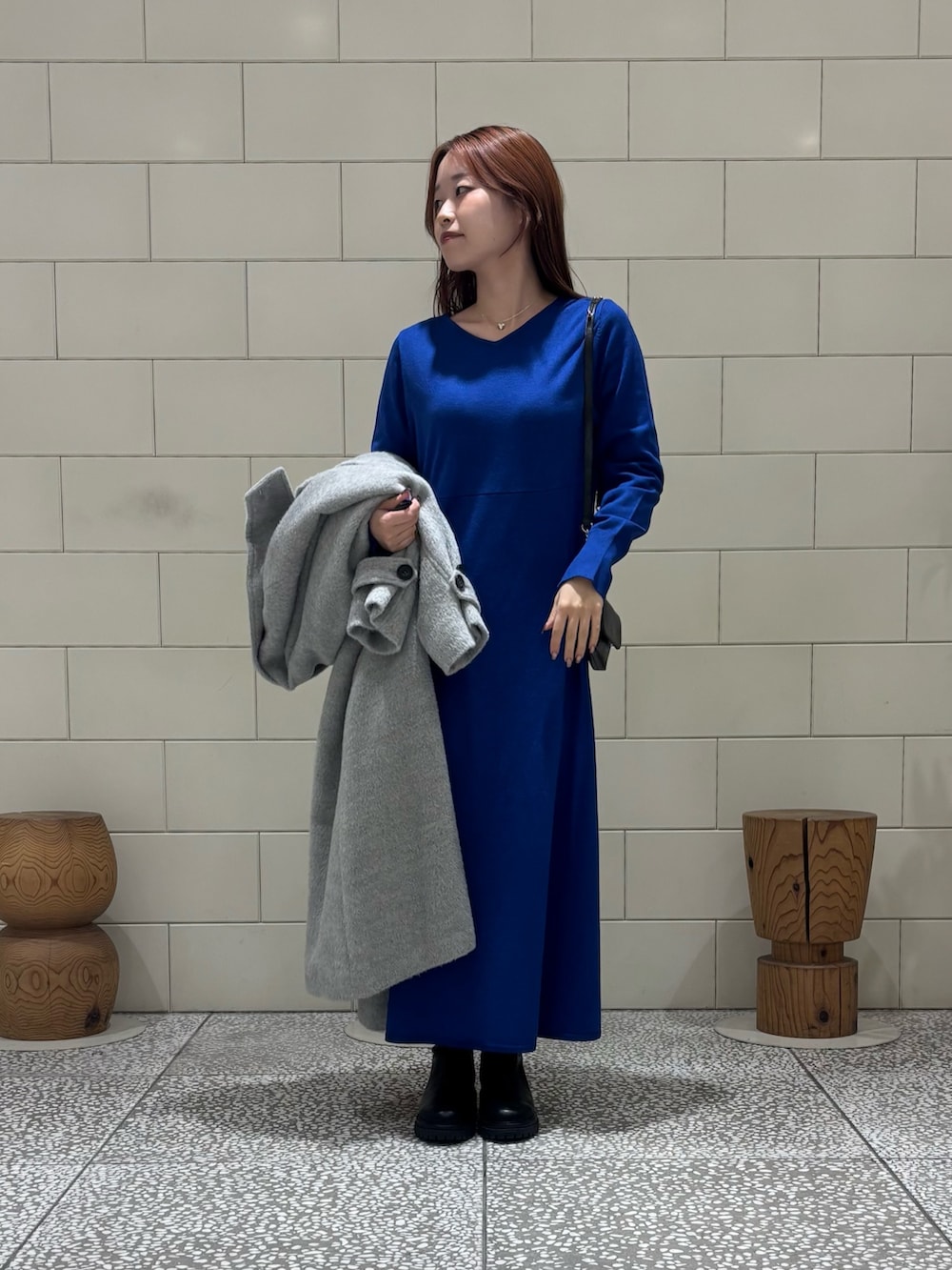 ブラック系のショルダーバッグ、ブラック系のブーツ、グレー系のその他アウターを着用したレディースの冬コーディネートの4枚目の写真