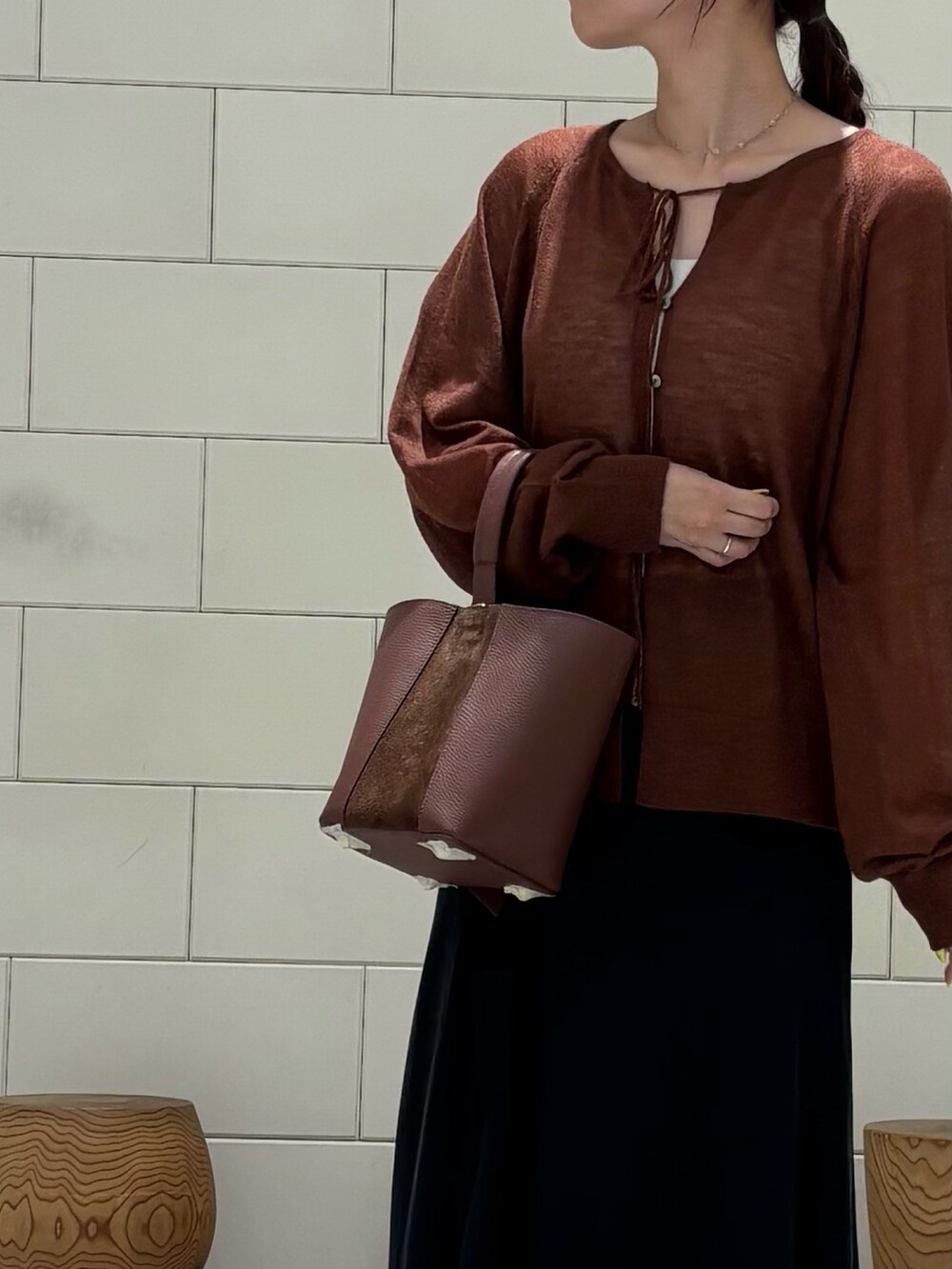 ブラック系のスカート、ブラック系のブーツ、ブラウン系のカーディガン/ボレロを着用したレディースの秋コーディネートの4枚目の写真