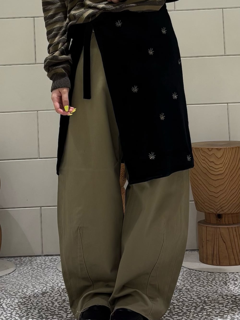 グリーン系のニット/セーター、ブラック系のスカート、ベージュ系のその他パンツを着用したレディースの秋コーディネートの5枚目の写真