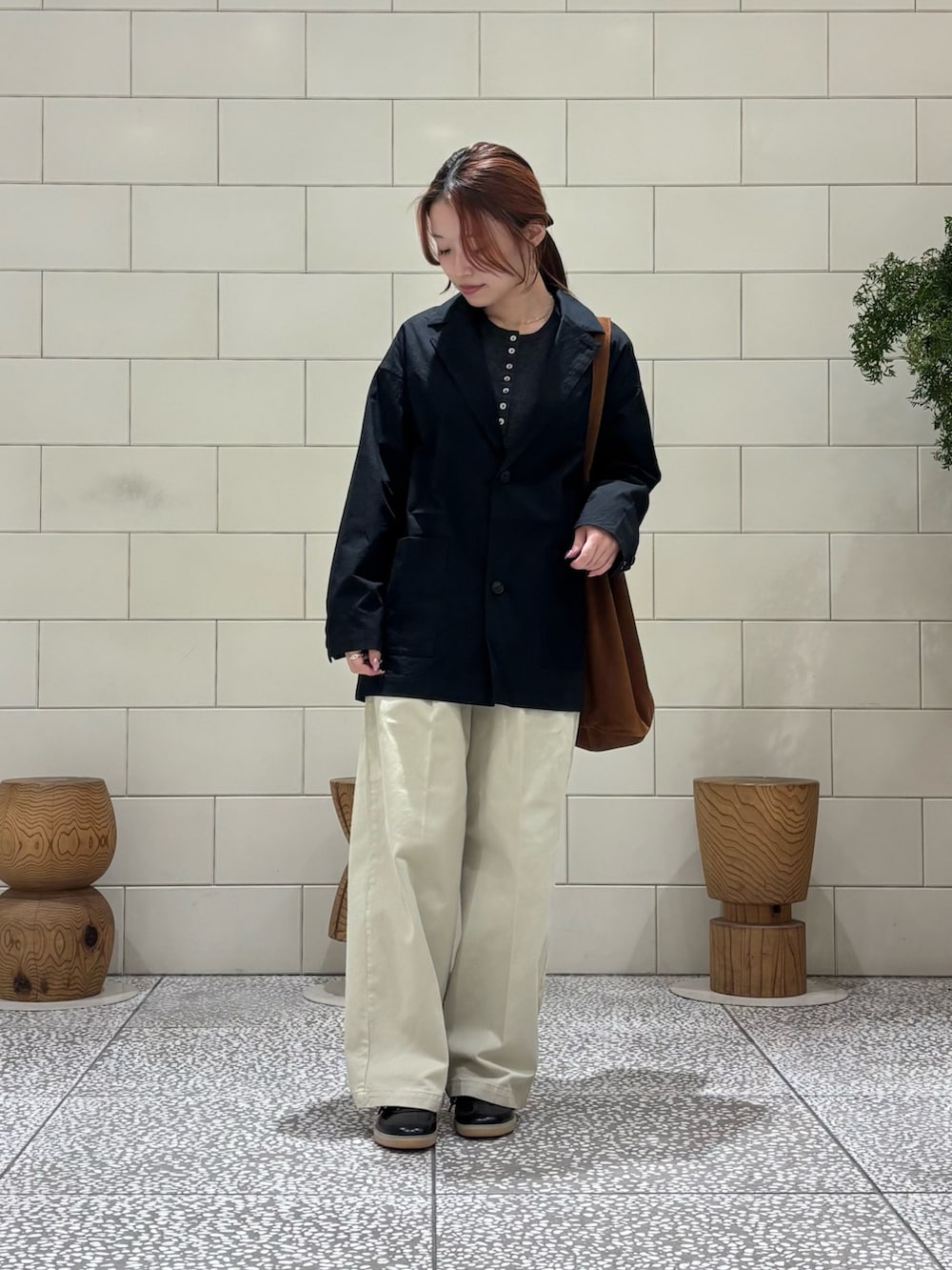 グレー系のニット/セーター、ブラウン系のトートバッグ、ブラック系のその他アウターを着用したレディースの冬コーディネートの2枚目の写真