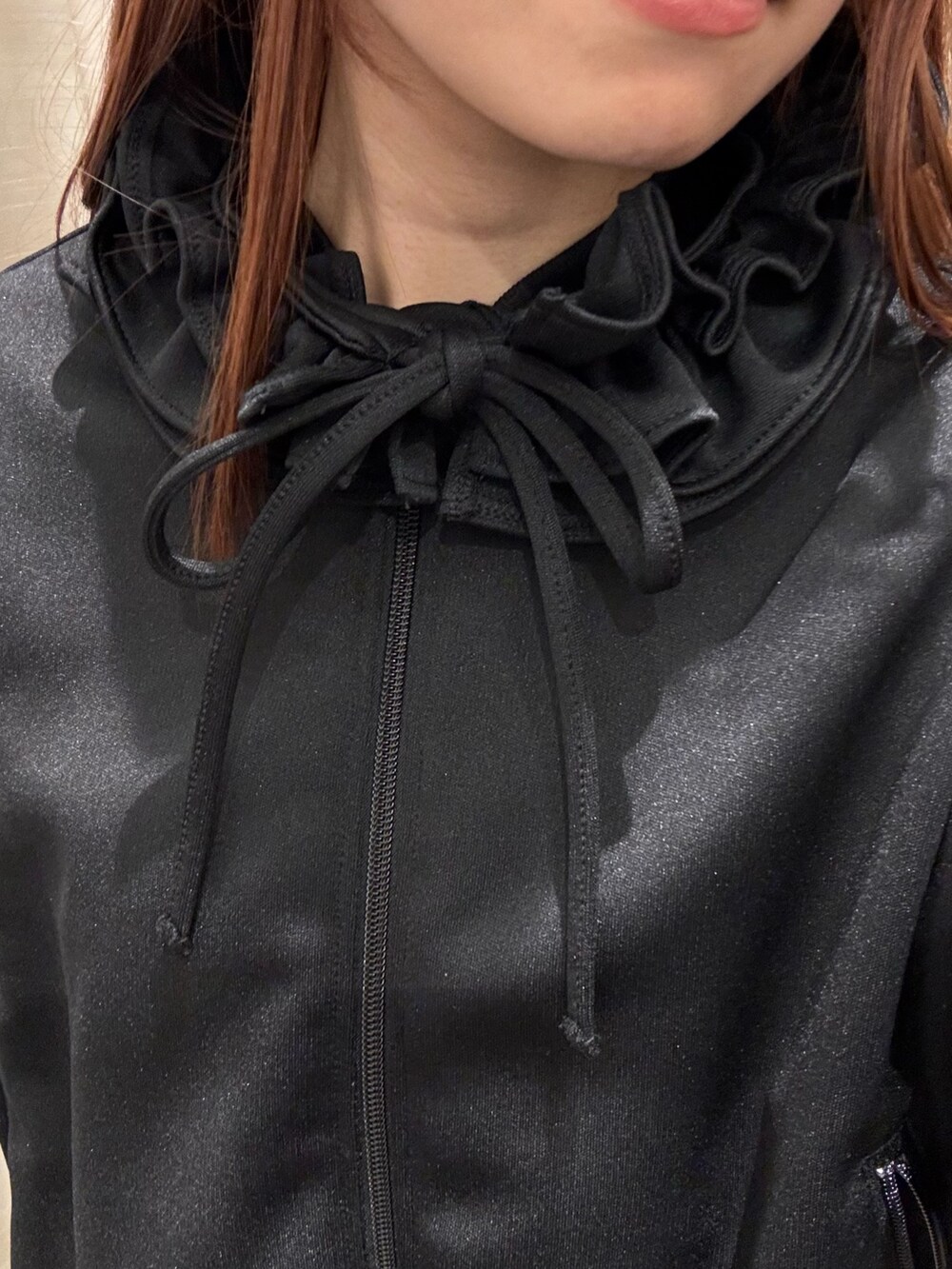 ブラック系のブルゾン、グリーン系のカーディガン/ボレロ、ブラック系のデニムパンツを着用したレディースの冬コーディネートの6枚目の写真