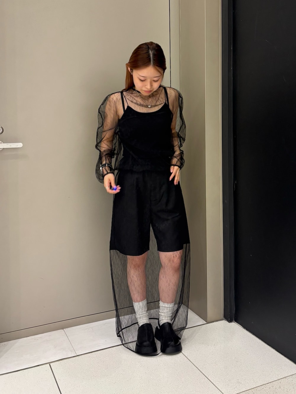 ブラック系のキャミソール、ブラック系のTシャツ/カットソー、ブラック系のスカートを着用したレディースの秋コーディネートの4枚目の写真