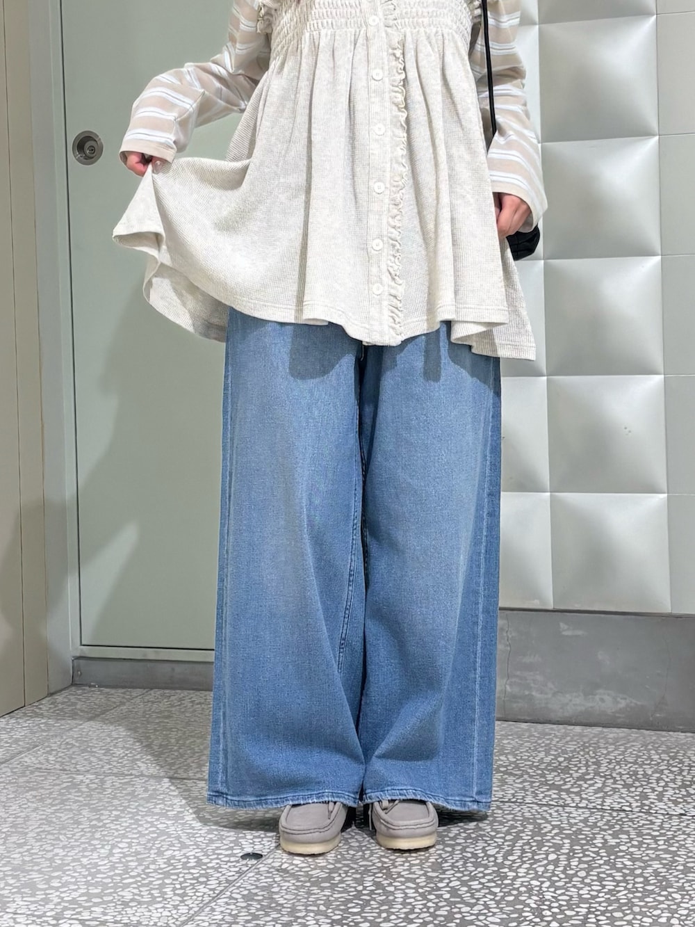 ベージュ系のシャツ/ブラウス、ブルー系のデニムパンツ、ブラック系のショルダーバッグを着用したレディースの春コーディネートの3枚目の写真