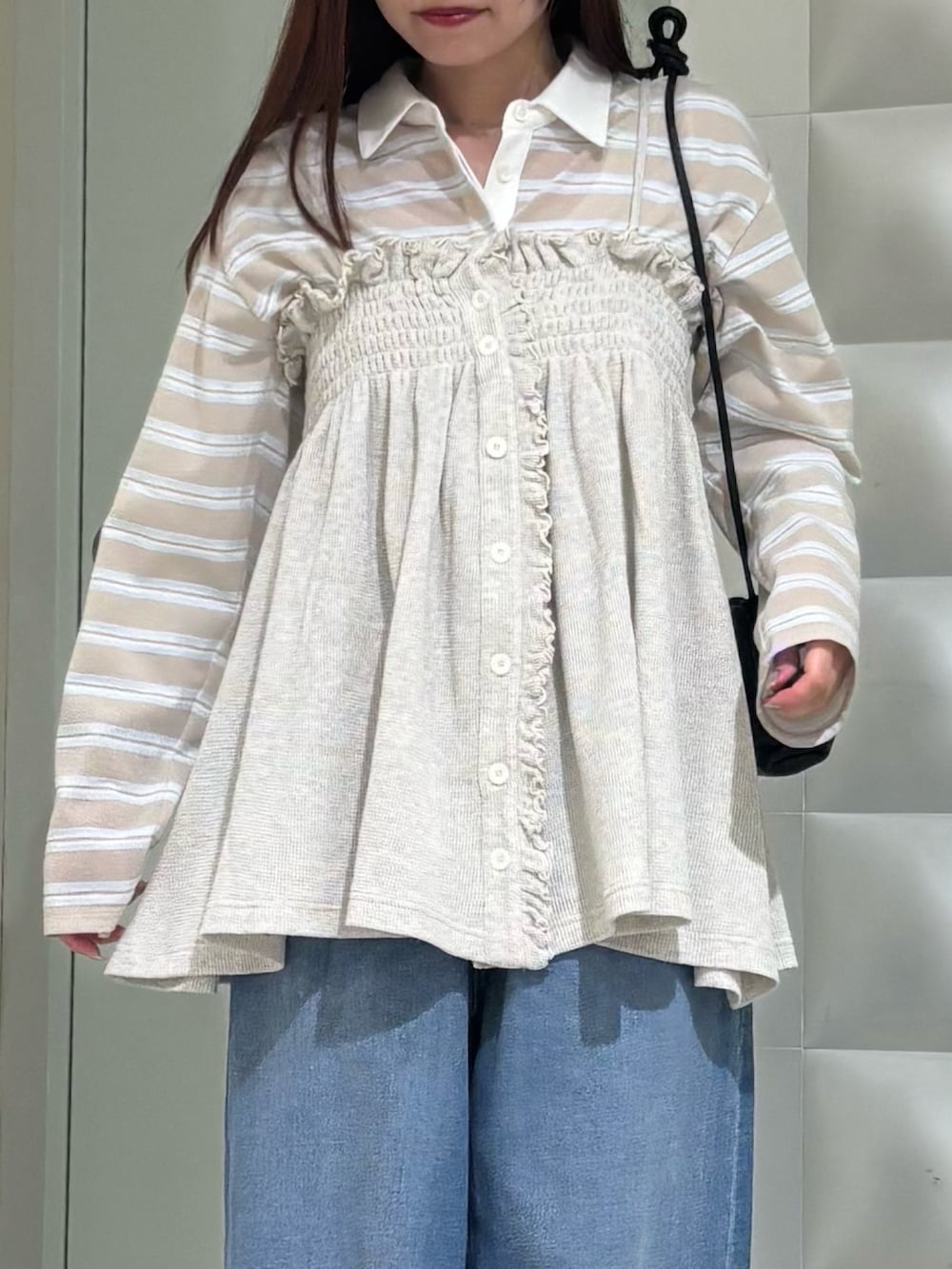 ベージュ系のシャツ/ブラウス、ブルー系のデニムパンツ、ブラック系のショルダーバッグを着用したレディースの春コーディネートの2枚目の写真