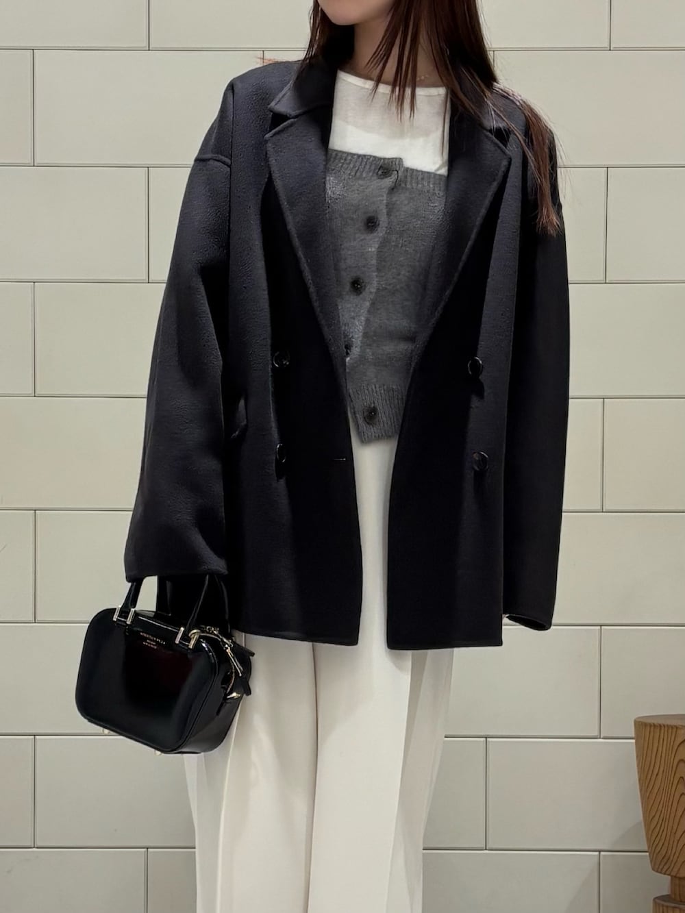 グレー系のニット/セーター、グレー系のその他アウター、ホワイト系のその他パンツを着用したレディースの秋コーディネートの2枚目の写真