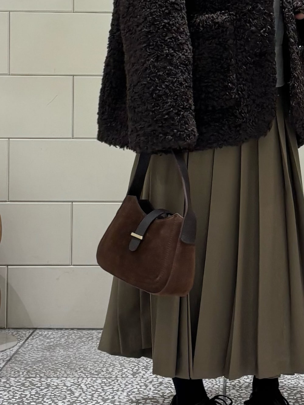 ブラウン系のスニーカー、グリーン系のスカート、ブラウン系のその他アウターを着用したレディースの秋コーディネートの5枚目の写真