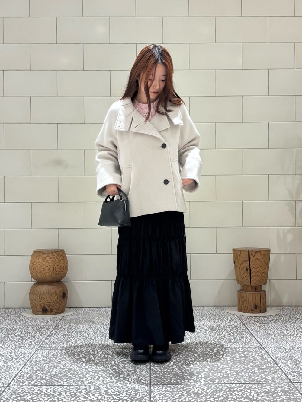 ピンク系のニット/セーター、ブラック系のスカート、ホワイト系のその他アウターを着用したレディースの冬コーディネートの2枚目の写真