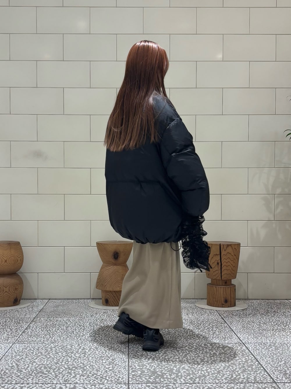 ブラック系のダウンジャケット/コート、ブラック系のニット/セーター、ベージュ系のスカートを着用したレディースの冬コーディネートの4枚目の写真