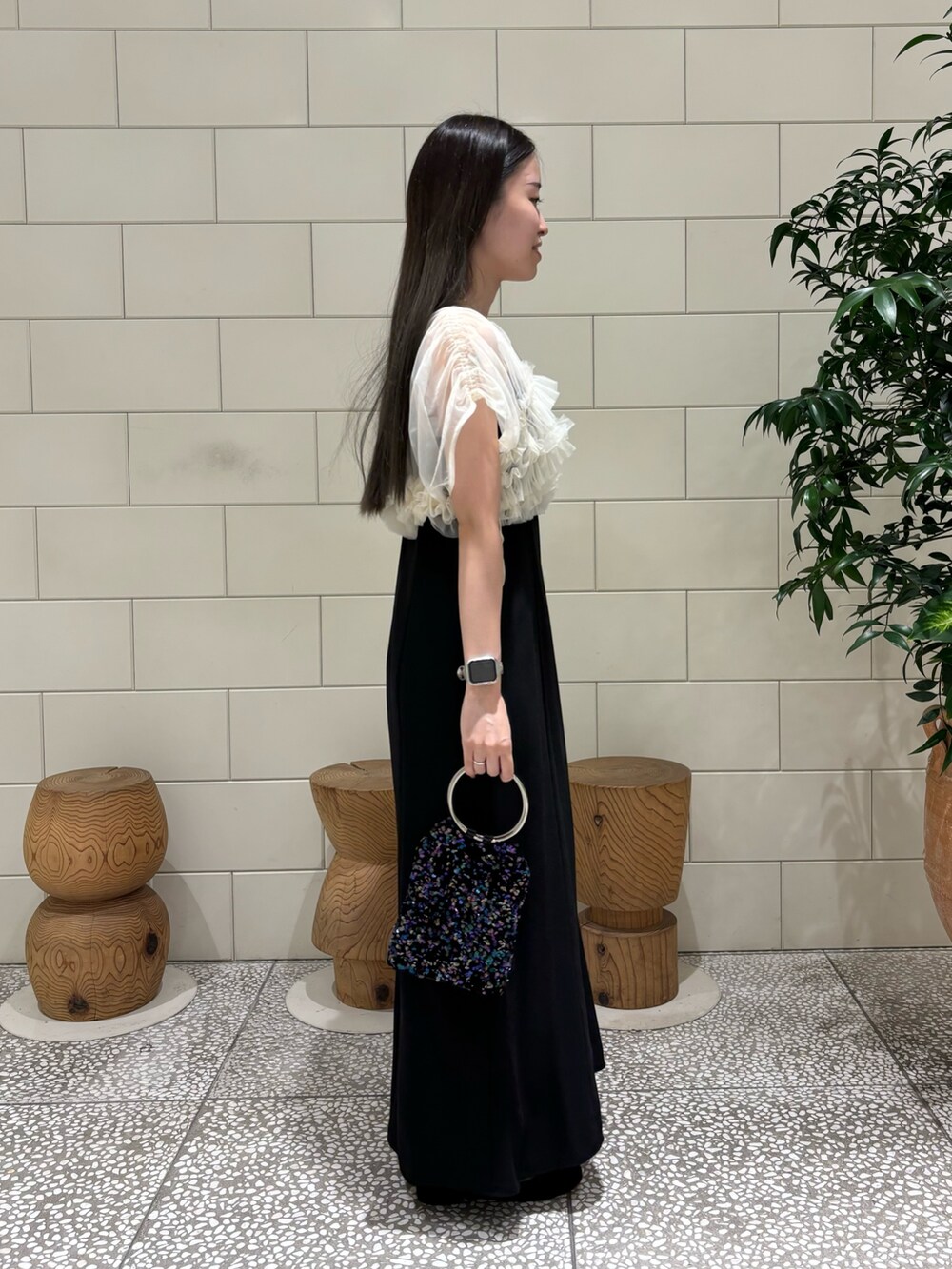 ブラック系のワンピース、パープル系のハンドバッグ、シルバー系のネックレスを着用したレディースの秋コーディネートの3枚目の写真