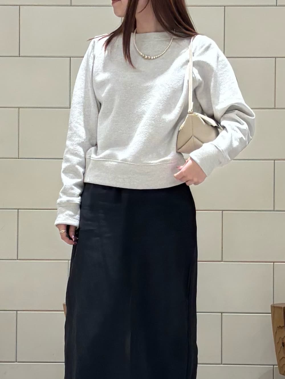 ホワイト系のスウェット、ホワイト系のスカート、ブルー系のデニムパンツを着用したレディースの冬コーディネートの3枚目の写真