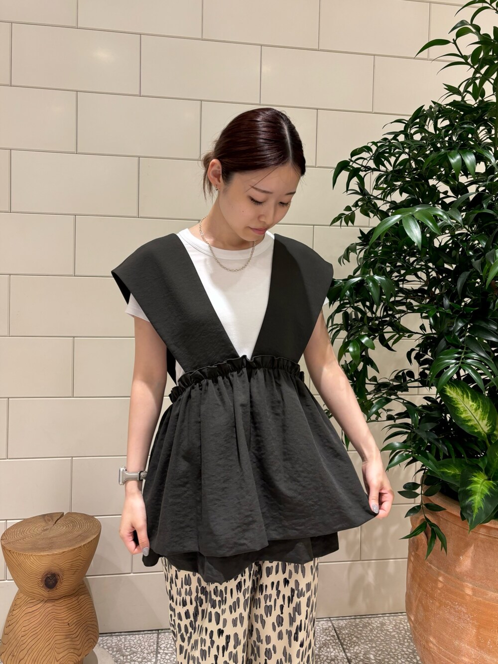 グレー系のベスト、ホワイト系のその他パンツ、ホワイト系のTシャツ/カットソーを着用したレディースの夏コーディネートの2枚目の写真