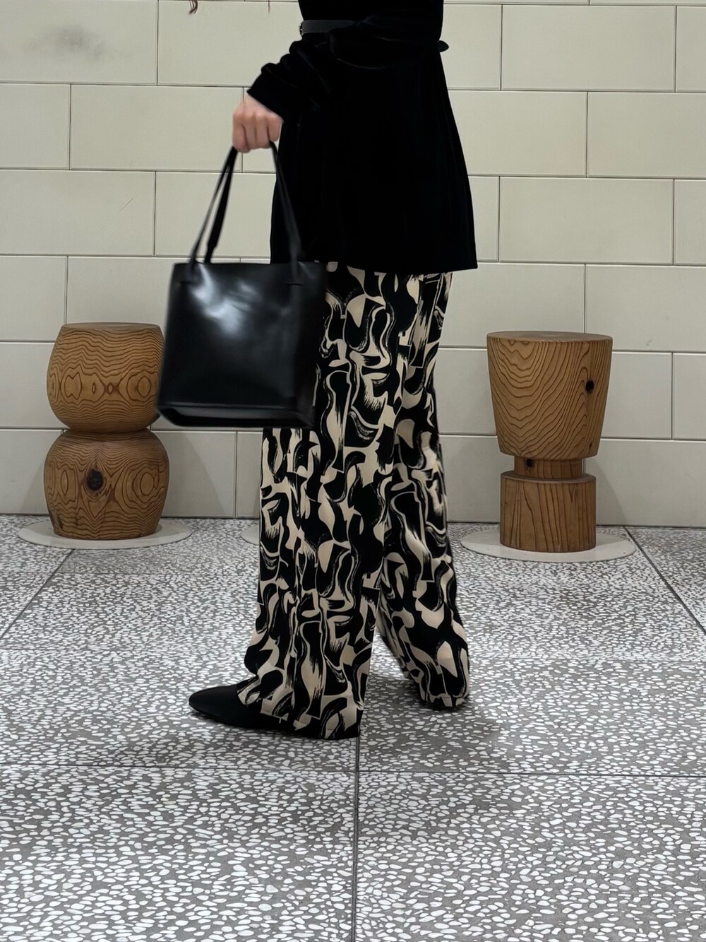 ブラック系のカーディガン/ボレロ、ブラック系のその他パンツ、ブラック系のハンドバッグを着用したレディースの秋コーディネートの4枚目の写真