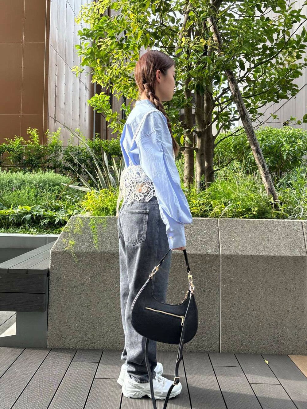 グレー系のデニムパンツ、ホワイト系のスニーカー、ブラック系のショルダーバッグを着用したレディースの夏コーディネートの2枚目の写真