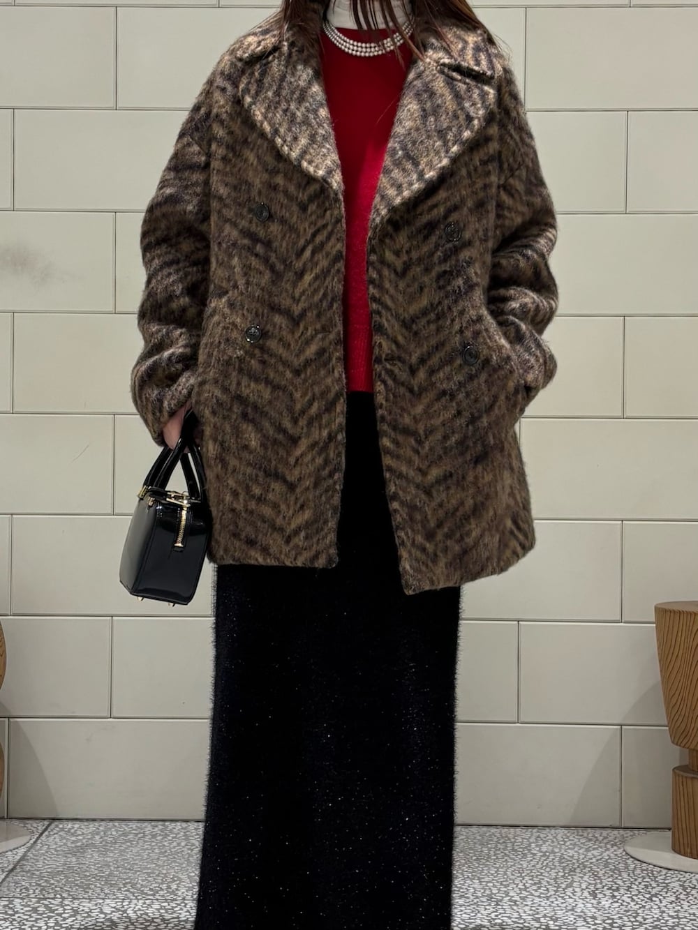 ホワイト系のTシャツ/カットソー、レッド系のニット/セーター、ベージュ系のピーコートを着用したレディースの秋コーディネートの6枚目の写真