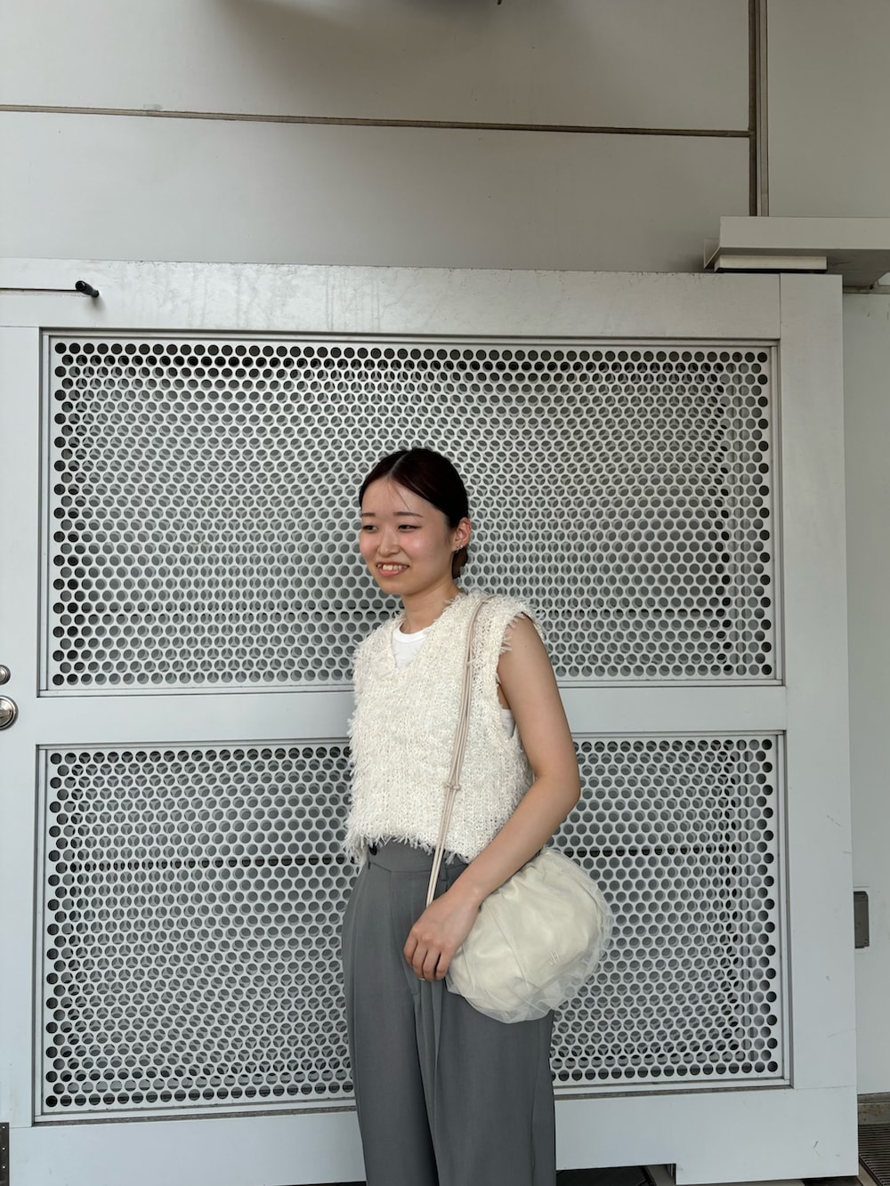 グレー系のその他パンツ、ホワイト系のショルダーバッグ、ホワイト系のベストを着用したレディースの夏コーディネートの4枚目の写真