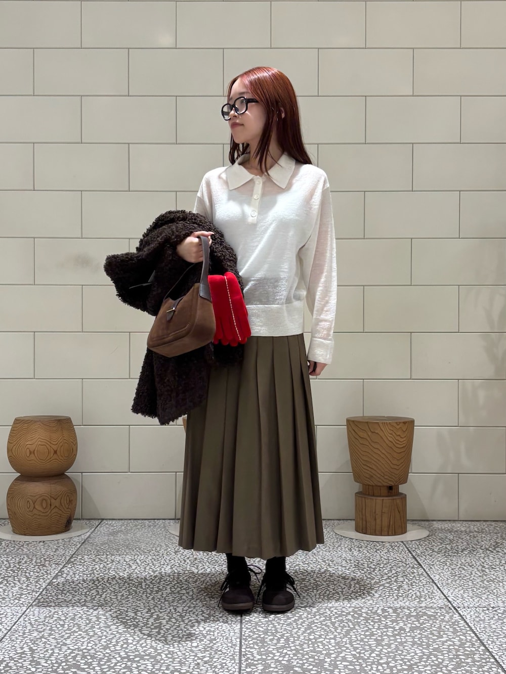 ブラウン系のスニーカー、グリーン系のスカート、ブラウン系のその他アウターを着用したレディースの秋コーディネートの2枚目の写真