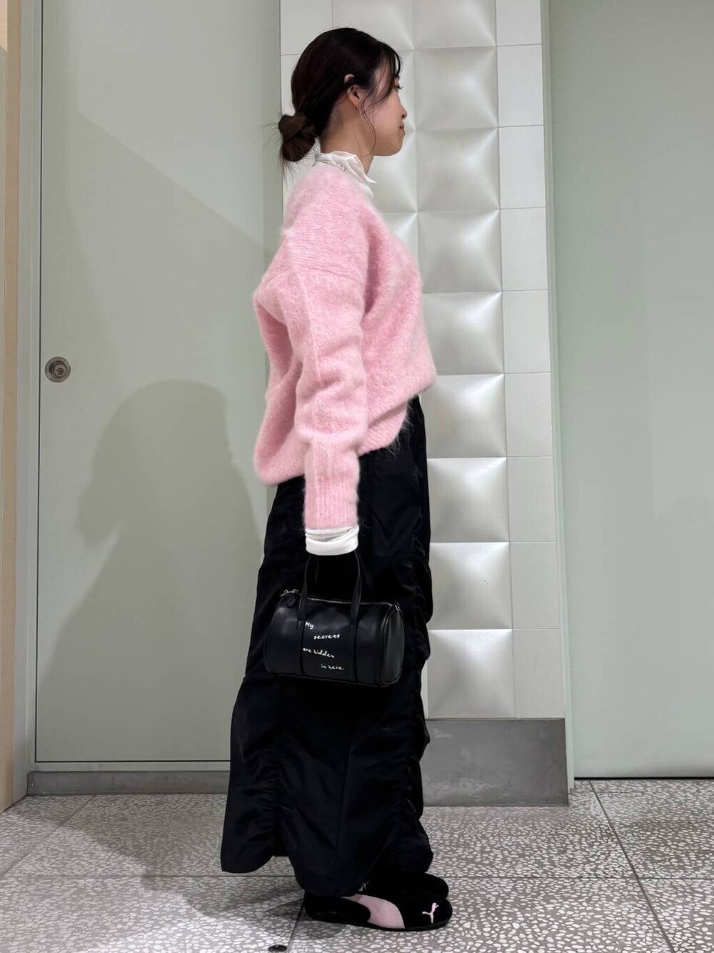 ホワイト系のTシャツ/カットソー、ブラック系のボストンバッグ、ブラック系のスカートを着用したレディースの冬コーディネートの2枚目の写真