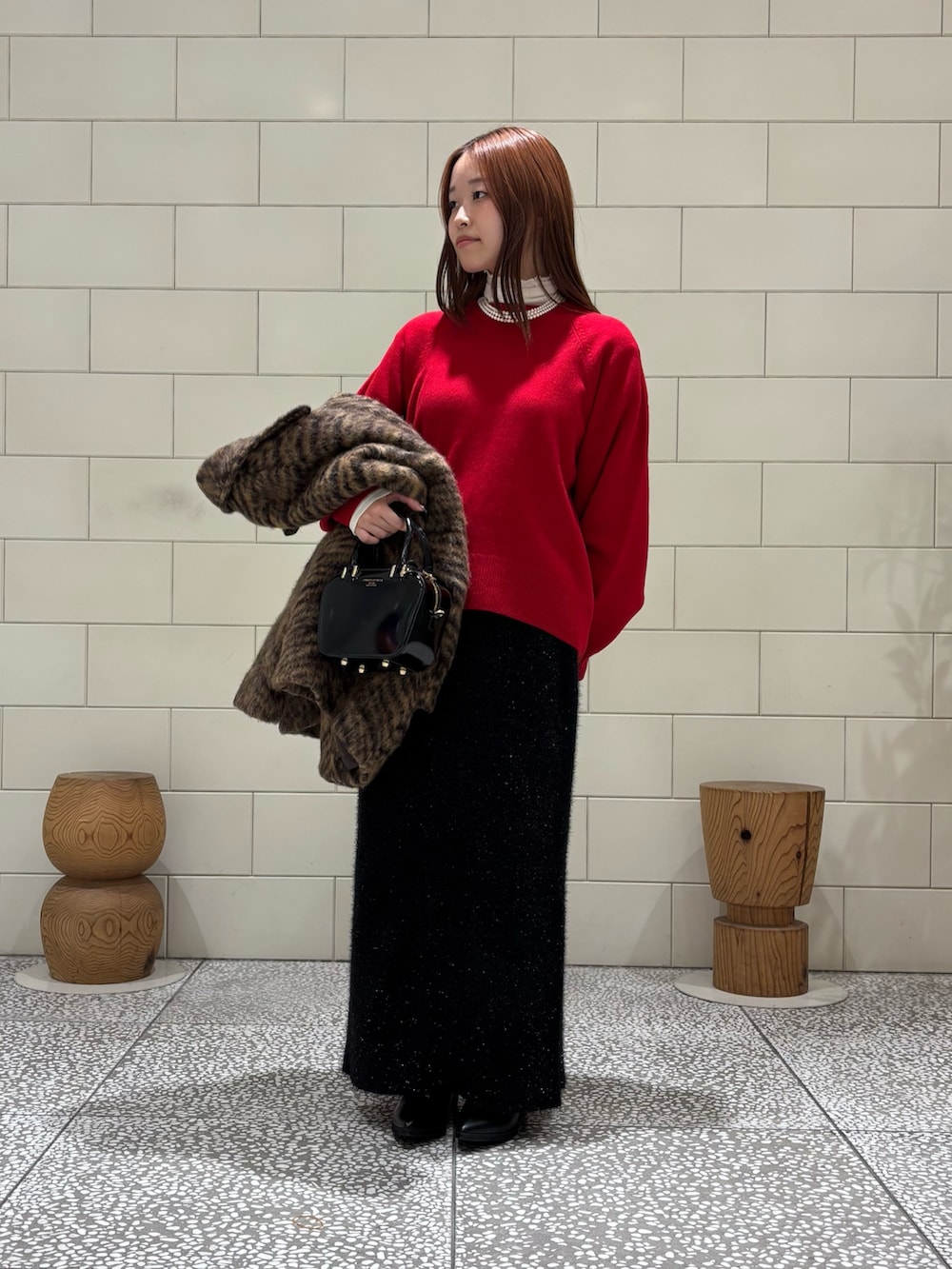 ホワイト系のTシャツ/カットソー、レッド系のニット/セーター、ベージュ系のピーコートを着用したレディースの秋コーディネートの2枚目の写真