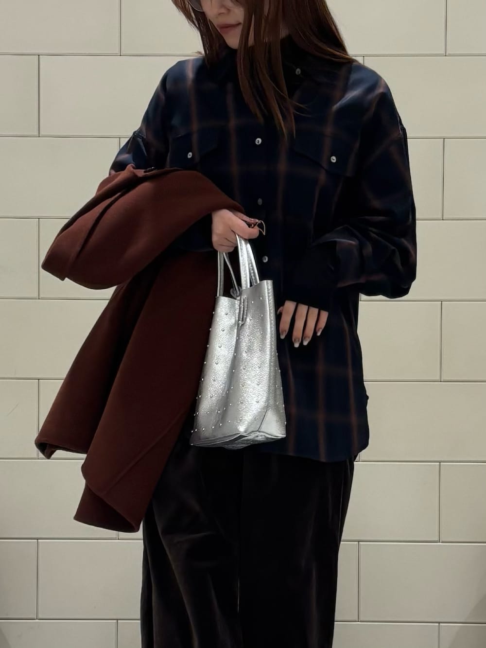 ブラック系のTシャツ/カットソー、ブラウン系のステンカラーコート、シルバー系のトートバッグを着用したレディースの冬コーディネートの6枚目の写真