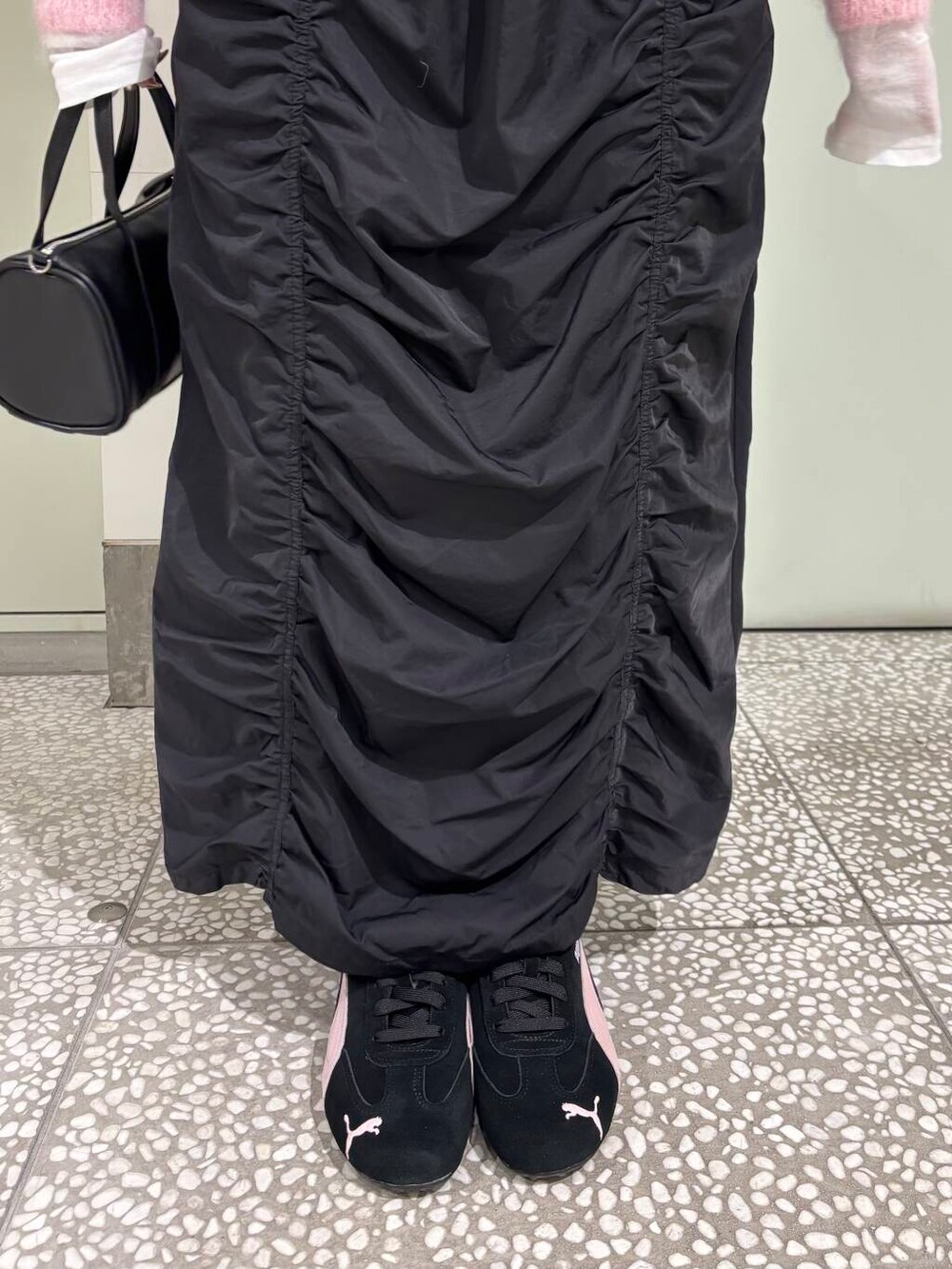 ホワイト系のTシャツ/カットソー、ブラック系のボストンバッグ、ブラック系のスカートを着用したレディースの冬コーディネートの5枚目の写真